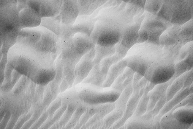 Schwarzweißbild von Strukturen im Sand.