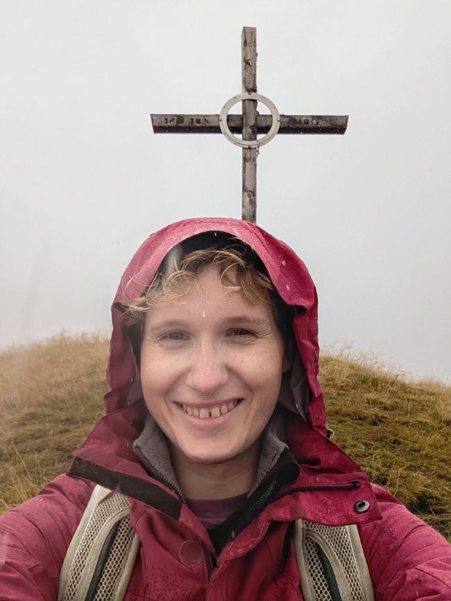 Bild von mir im Regen vor einem Gipfelkreuz, das zugegeben nur 50 Meter von der Mittelstation weg war.