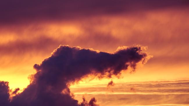 Eine Wolke die von Hinten vom Sonnenuntergang angestrahlt wird. Sie selbst ist eher dunkel und hat Anteile von Lila in sich. Nach außen hin leuchtet der Himmel in allen Orange, Rot und Gelb Tönen