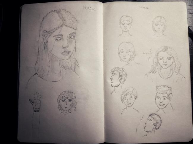 Zwei Seiten eines Skizzenbuchs. Darauf zu sehen sind verschiedene Zeichnungen von Gesichtern in verschiedenen Positionen und Stilen. Außerdem eine Hand.